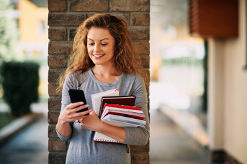 Female student using smartphone outdoor.
