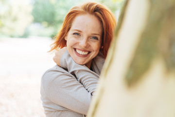 Cute vivacious redhead woman with beaming smile
