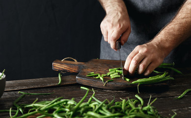 Man cutting green bean wooden cutting board Healthy vegetarian food