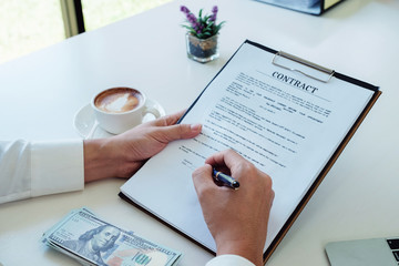 male hand holding pen to signature Contract application for Signing of Business Agreement.