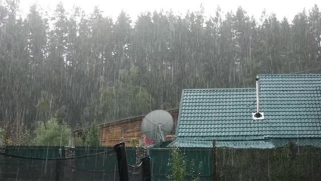 Heavy rain shower in backyard at unfinished house. slow motion