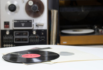 Vinyl record with copy space in front of a collection albums dummy titles. Reel Tape Recorder