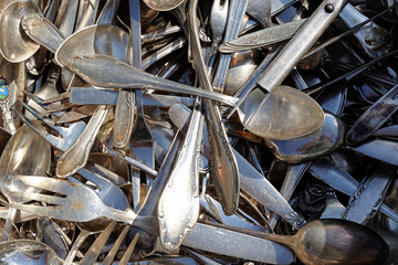 A large pile of old and antique cutlery for sale at the flea market