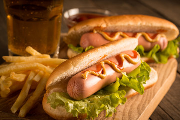 Photo of barbecue grilled hot dog with yellow mustard and ketchup on wooden background. Hot dog...