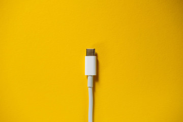 Charger Cable for Smartphone on Yellow Background. Top View. copy Space for insert text.