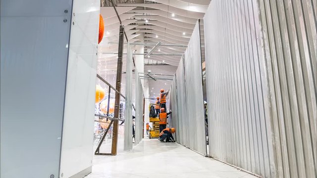 workers install metal wall between stores in center timelapse