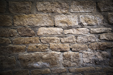 Antique masonry, fragment of ancient crumbling limestone brick fortress wall, background with darkened vignette