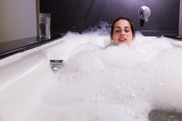 Woman taking a bath of foam