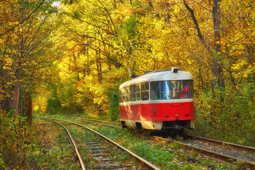 Red retro tram goes along the route