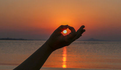sunset over the sea captured between two fingers II