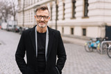 Street portrait of smiling mature man with glasses