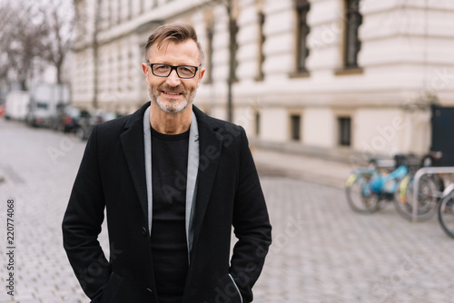Street portrait of smiling mature man with glasses