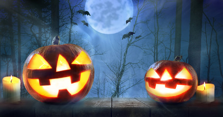 Halloween pumpkins against night scary autumn forest background