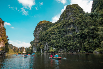 Fototapeta na wymiar Boats On A River around mountains in asia