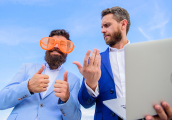 Unprofessional behaviour. Businessman with laptop serious while business partner ridiculous glasses...