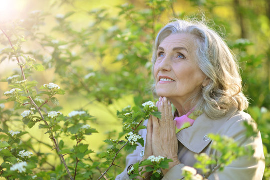 Portrait of a senior woman praying outdoors