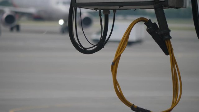 Close up of yellow and black big cables hanging under jet bridge in the airport