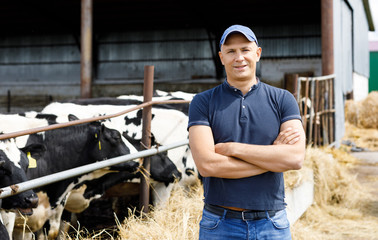 positive farmer with cows at farm