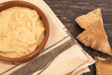 Background image of humus with pitta bread on a dark wooden background 