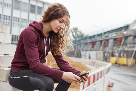 Junge Frau liest Nachricht auf Smartphone