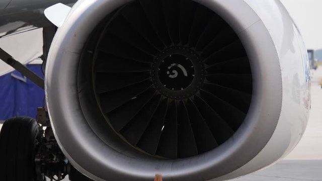 Close up of jet engine. Aircraft with stopped turbines stays on airport ramp