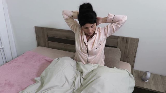 Woman stretch sitting in bed