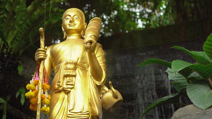 Golden Buddhist Statue and Waterfall