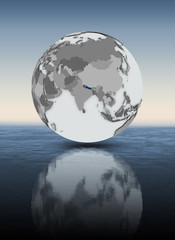 Nepal on globe above water