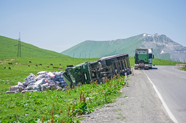 inverted big truck on a mountain road