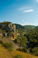 Beautiful top view of a lonely and cute house in a mountain cliff next to the river Jucar in Cuenca. View from lookout Ventano del Diablo.