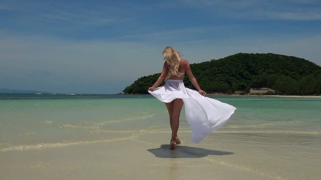 Young Caucasian Woman in White Skirt Walking on Tropical Sandy Beach