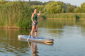 Fototapeta na wymiar Woman stand up paddleboarding