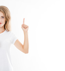 Portrait of a smiling young girl, woman pointing finger isolated on white background. Copy space.Blank