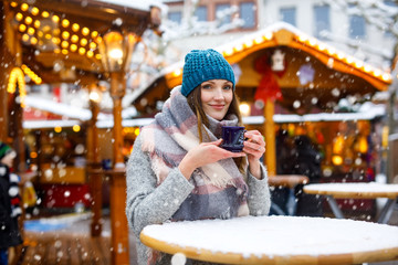 woman drinking hot punch on German Christmas market.