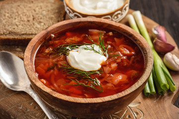 Borscht - traditional russian and ukrainian beetroot soup on wooden background.