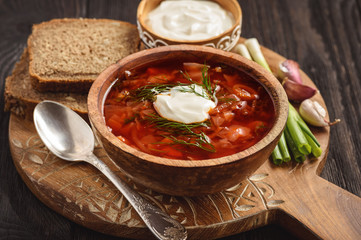 Borscht - traditional russian and ukrainian beetroot soup on wooden background.