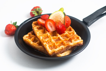 Food concept square Waffles and syrup with strawberry and fig topping in iron pan with copy space