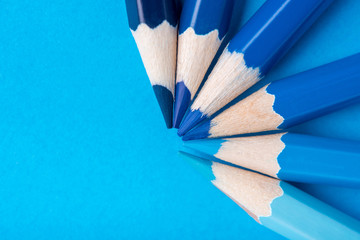 Macro photograph of several pencils of blue color on a paper background
