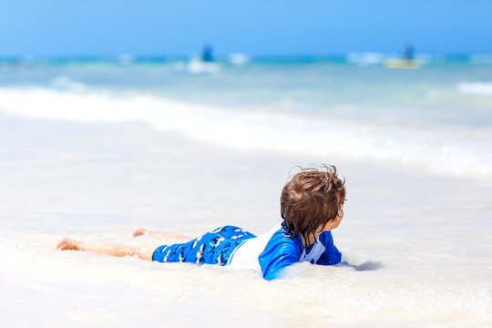 little blond kid boy having fun on tropical beach of Seychelles