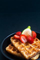 Food concept square Waffles and syrup with strawberry and fig topping in iron pan with copy space