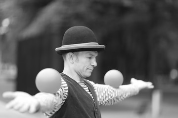 The clown juggles balls on the street of a European city