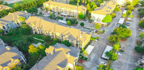 Panorama aerial view typical multi-level apartment building in US surrounded by green trees, row of...