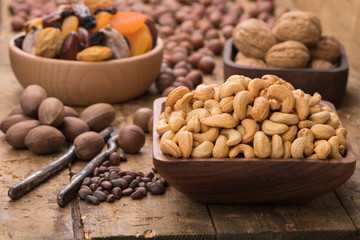 cashew nuts peeled roasted in wooden bowl on table, grunge style.