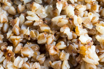 Macro shot of cooked buckwheat porridge and spoon. Extreme closeup.