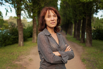 Mature woman walking in summer park outdoors