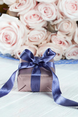 present gifts box. rose flowers and gift box with ribbon on light table. Greeting card for Birthday Womens or Mothers Day