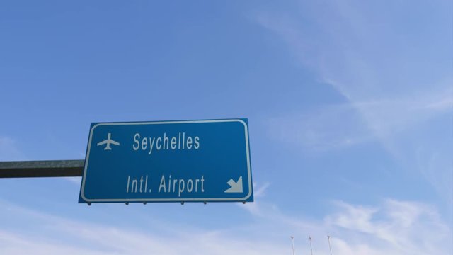 seychelles airport sign airplane passing overhead