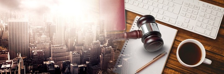 Gavel and keyboard with notepads and coffee on desk with