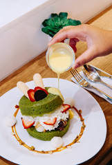 Fluffy Matcha cake pastry with cream, strawberry, Mochi and almond caramel sauce