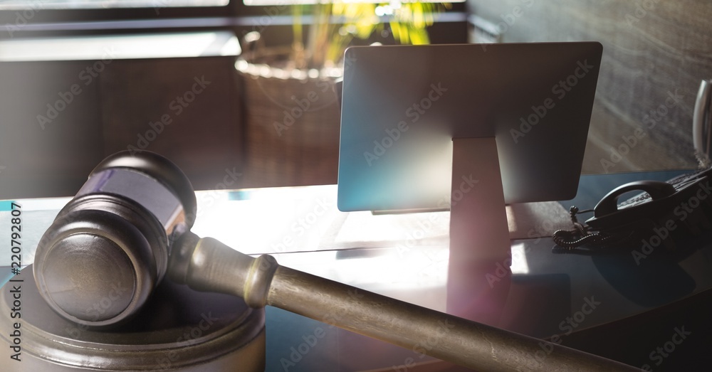 Wall mural Gavel and computer screen on desk